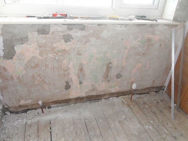 Beneath the window, showing the poor condition of the plaster in this room.