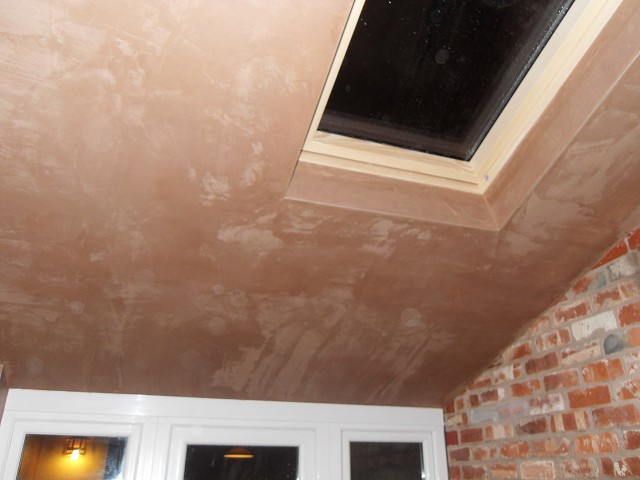 Finished plaster ceiling and feature brick wall.